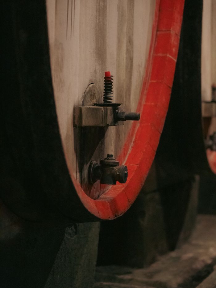 Close-up of a weathered wine barrel with red trim in a Trentino-South Tyrol cellar, Italy.